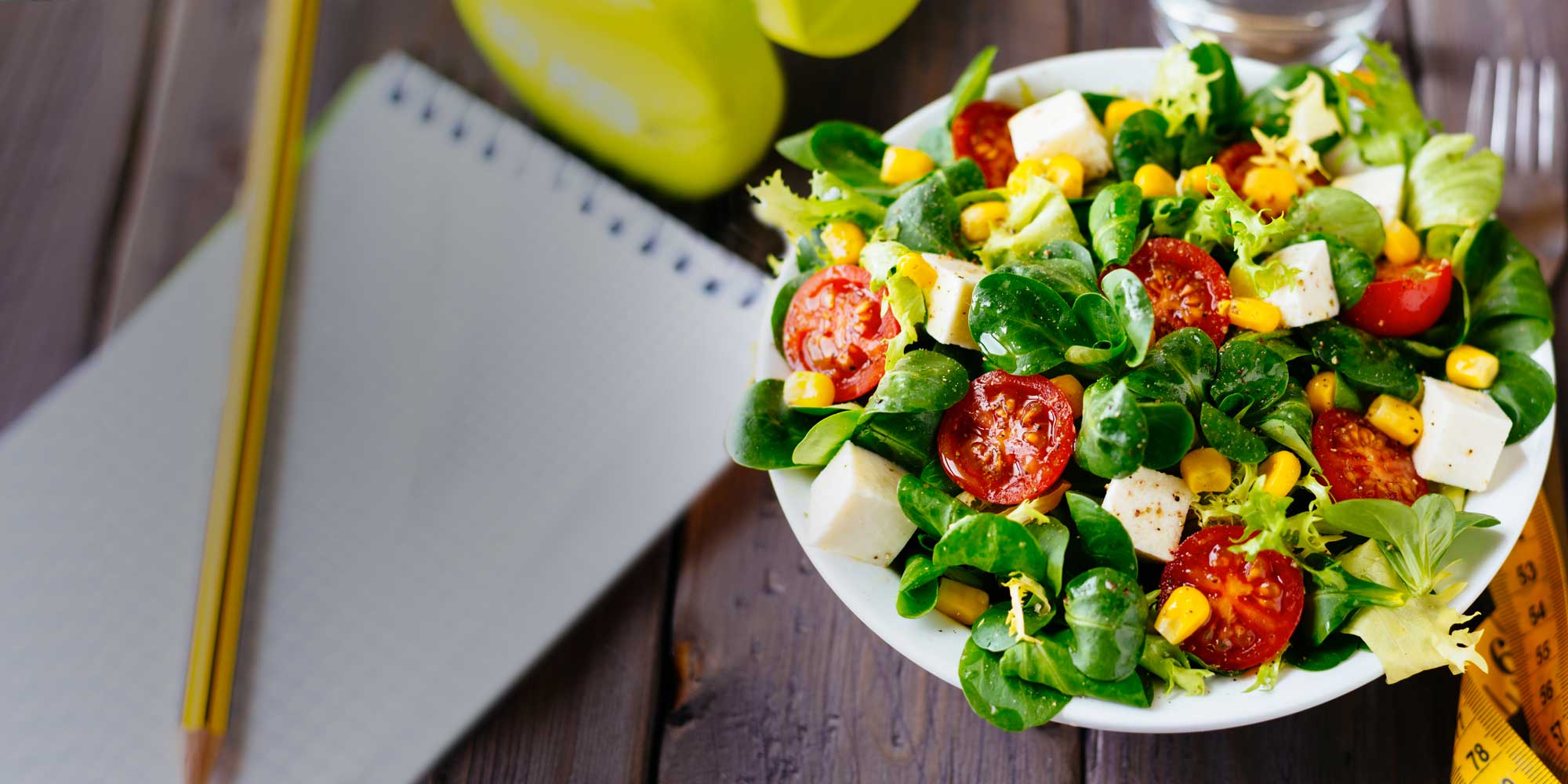 Fresh and healthy salad with tomatoes on an office desk